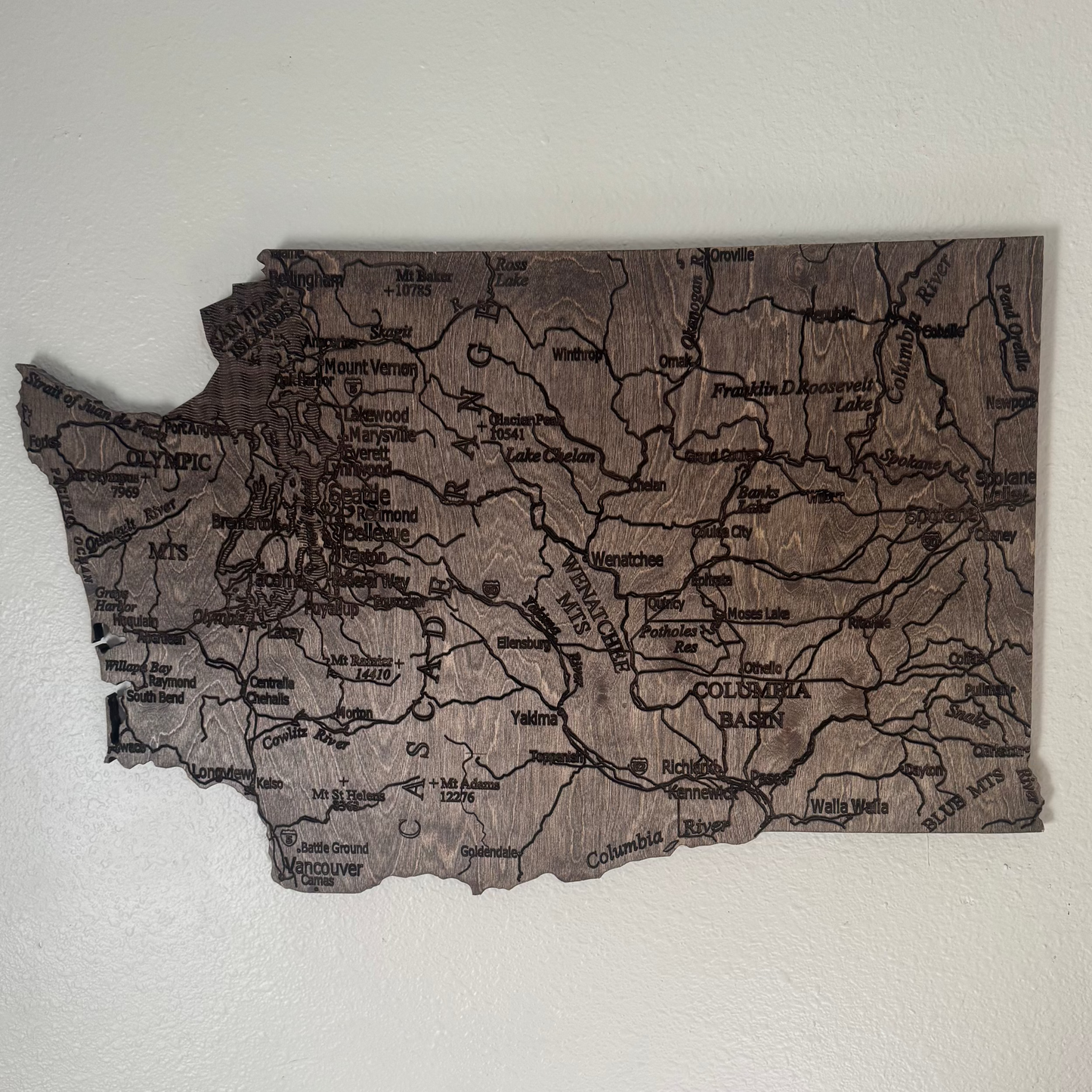Wooden map of Washington state on a white wall