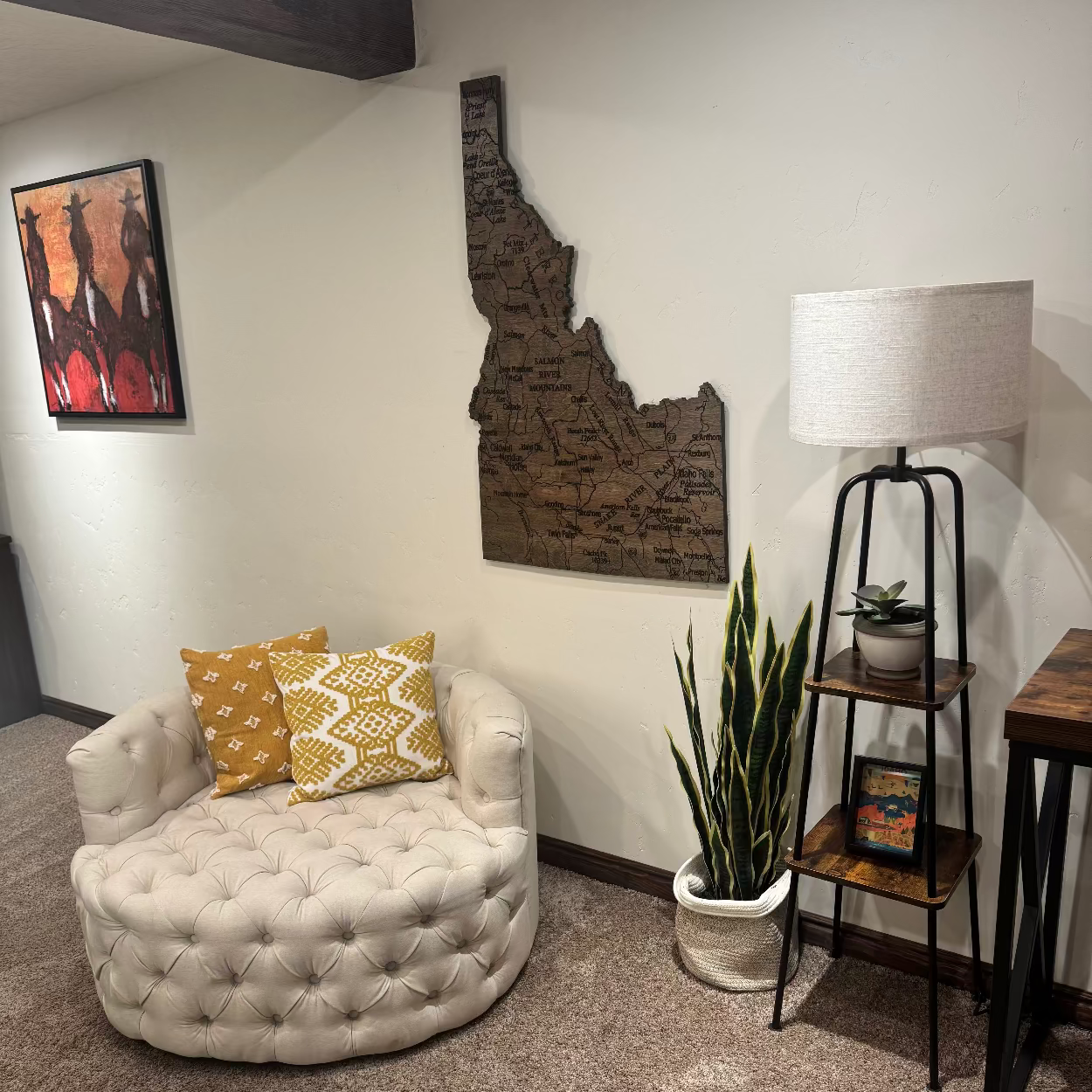 Living room with a white tufted chair, decorative pillows, a lamp, and a plant.