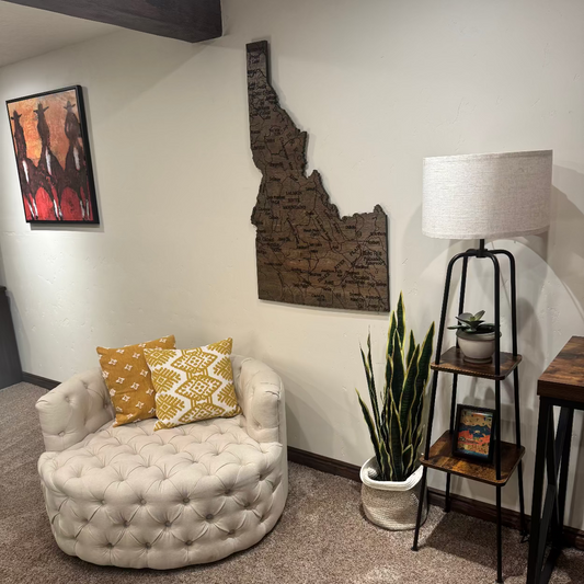 Living room with a white tufted chair, decorative pillows, a lamp, and a plant.
