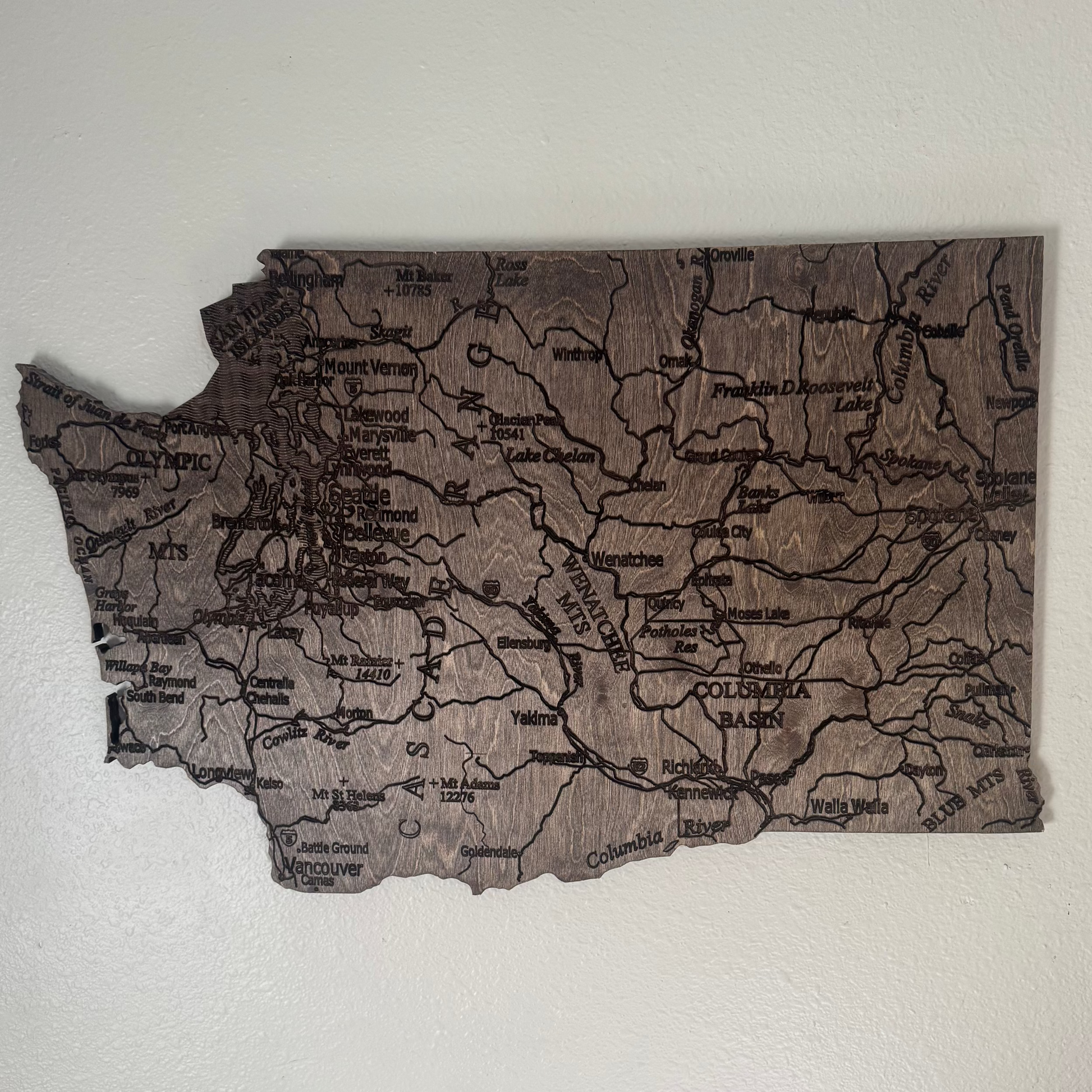 Wooden map of Washington state on a white wall